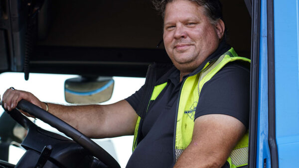 Chaufför från Skrotcentralen bakom ratten i en lastbil.